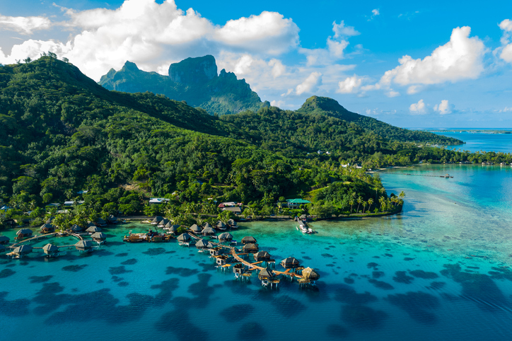 Bora Bora aerial drone video of travel vacation paradise with overwater bungalows luxury resort, coral reef lagoon ocean beach. Mount Otemanu, Bora Bora, French Polynesia, Tahiti, South Pacific Ocean