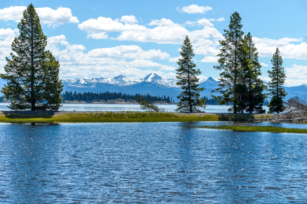 A spring view of Yellowstone Lake with snow-capped mountain range in the background, Yellowstone National Park, Wyoming, USA.