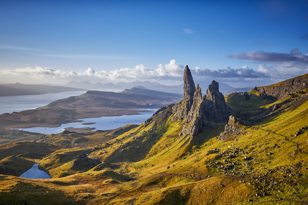 View Over Old Man Of Storr, Isle Of Skye, Scotland. During a beautiful sunrise and dramatic sky with a local shower here and there. The Old Man of Storr looms over Portree, Isle of Skye and is situated 7 miles north of the town. It is dominated by the 50 metre high petrified lava pinnacle of the Old Man of Storr, with a brutal tumble of cliff behind, and the panorama spreads across loch, sea and islands to the high mountains of the mainland beyond.