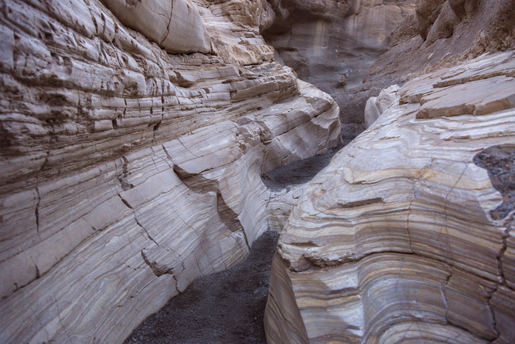 Canyon wall in Mosiac Canyon at Death Valley California showing a smooth eroded mosaic surface with many mineral layers folded and deformed by pressure.