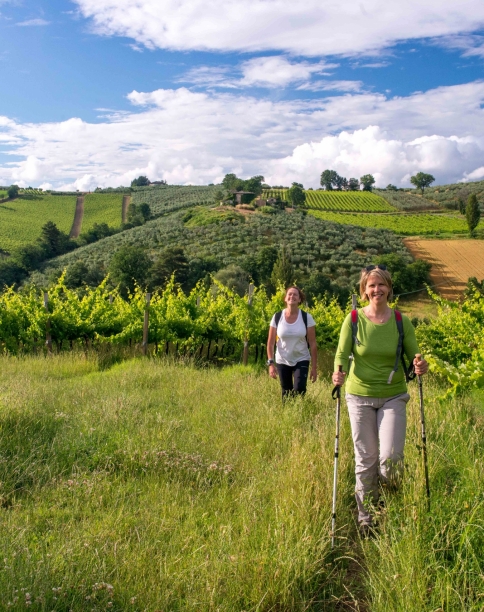 Two women walking through a green landscape