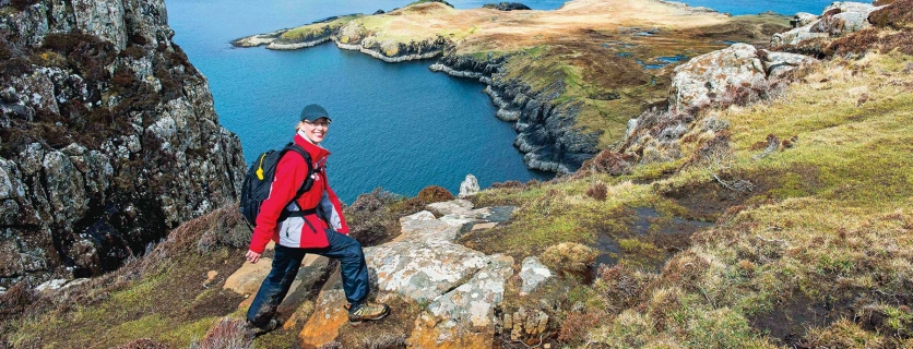 picture of a hiker walking along a ridge next to an inlet