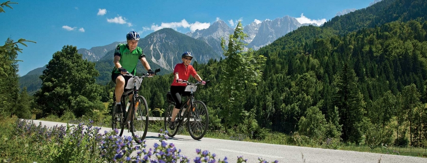 picture of two people biking with mountains in the distance