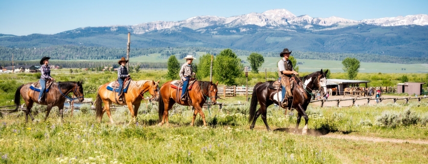 Young Family of four vacationing on horse back at Dude Ranch