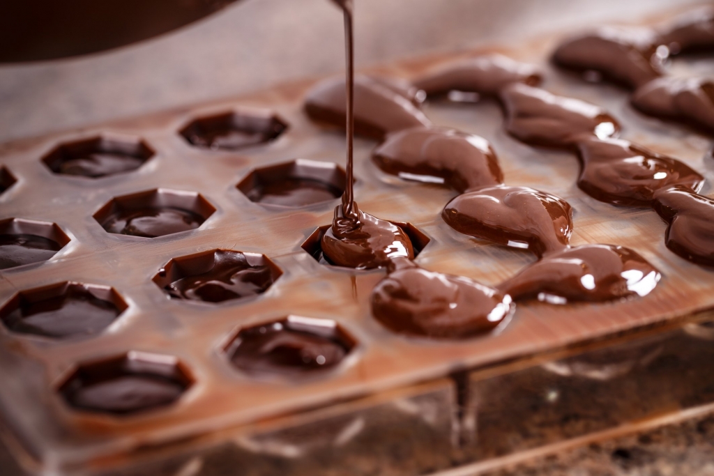 Putting chocolate in mold, make praline