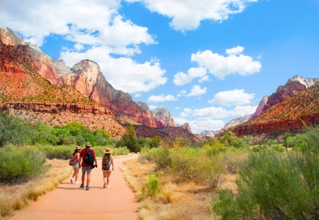 People on hiking trip in the mountains walking on pathway. Zion National Park, Utah, USA