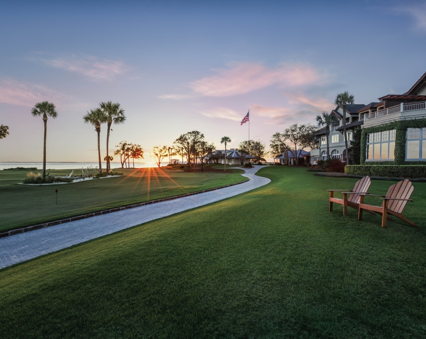 Two chairs on a beautiful lawn at sunset