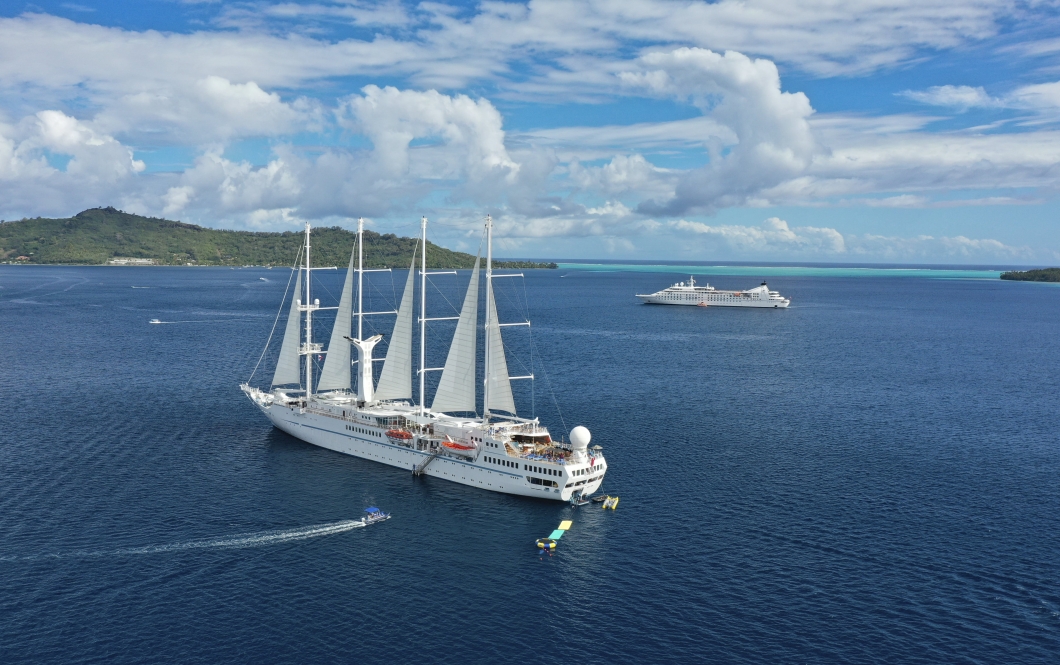 Twi cruise ships anchored on a beautiful day.