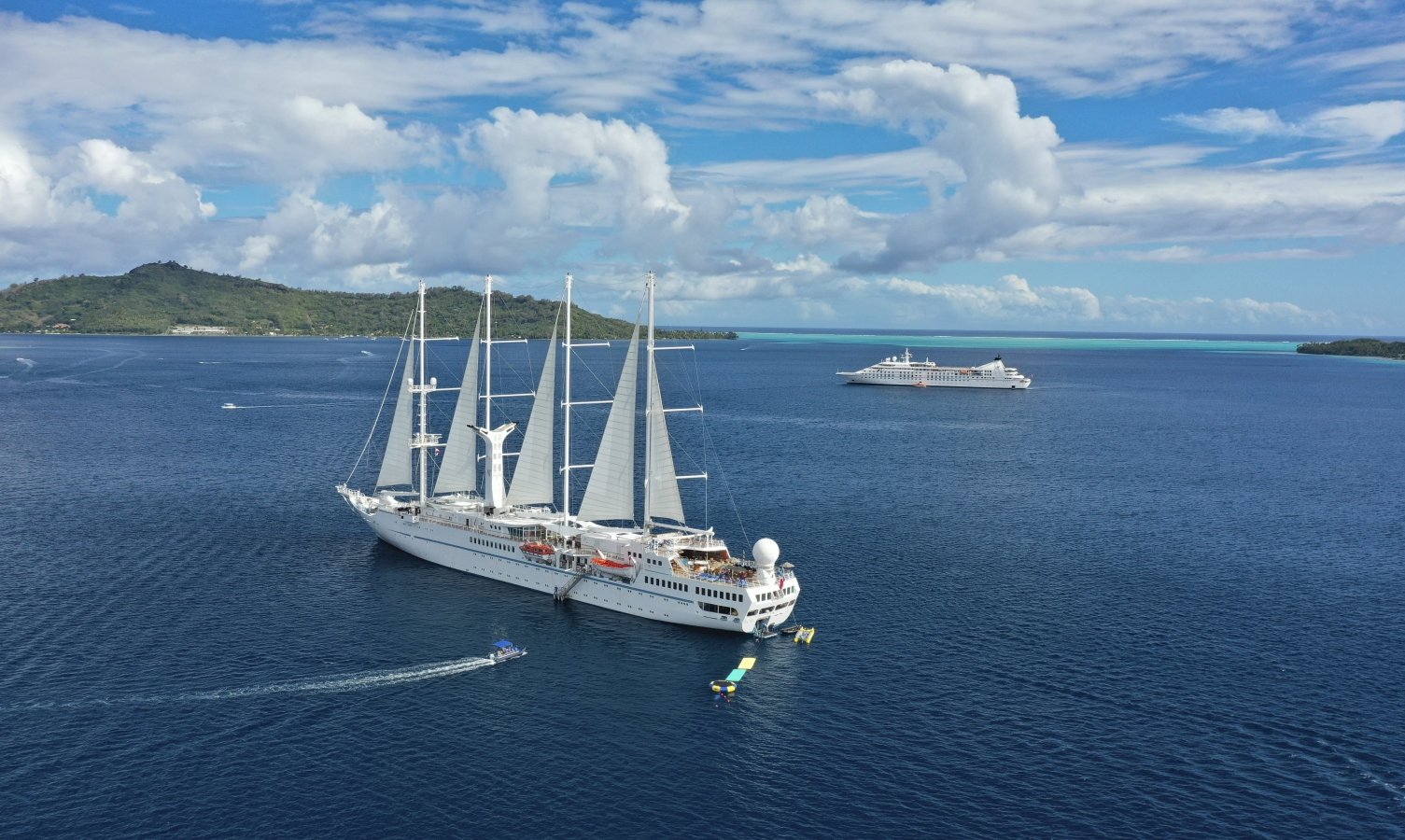 Twi cruise ships anchored on a beautiful day.