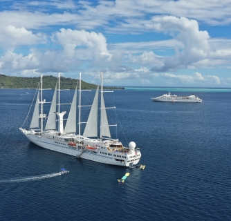 Twi cruise ships anchored on a beautiful day.