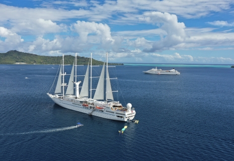 Twi cruise ships anchored on a beautiful day.