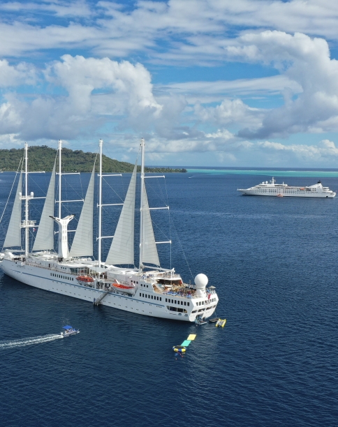 Twi cruise ships anchored on a beautiful day.