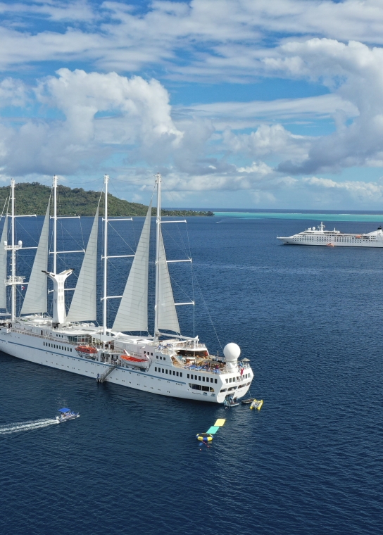 Twi cruise ships anchored on a beautiful day.