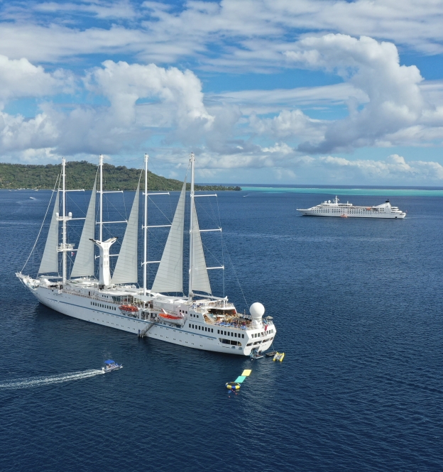 Twi cruise ships anchored on a beautiful day.