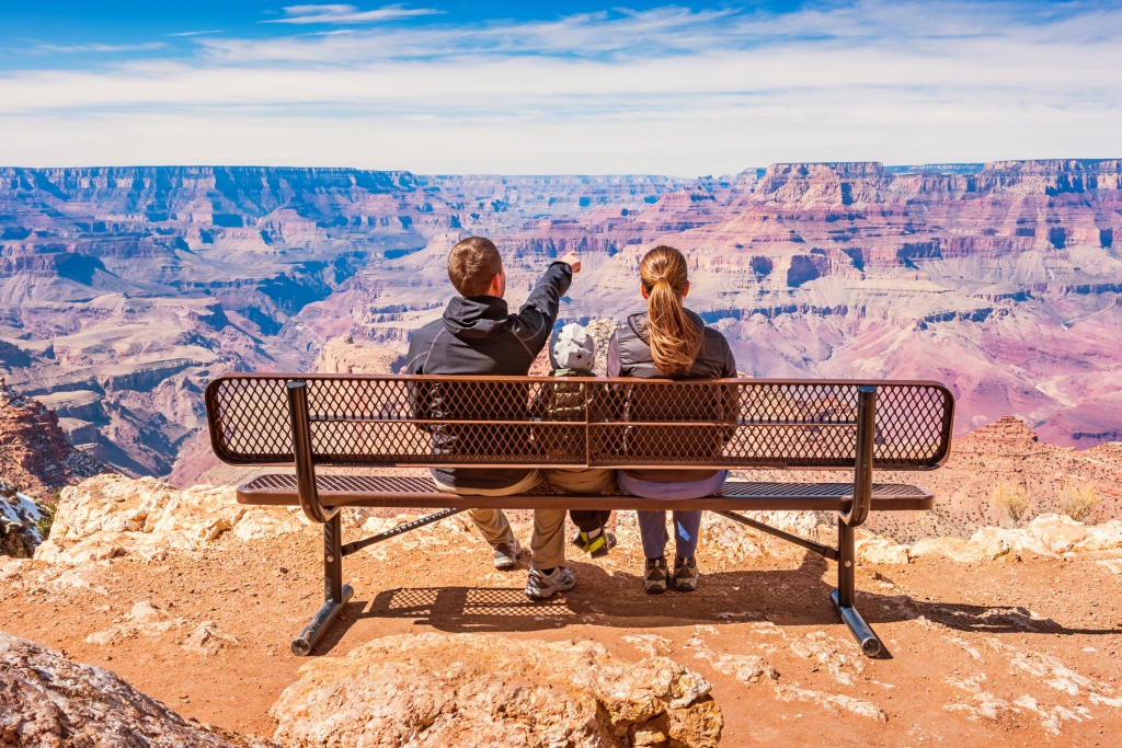 Stock photograph of a family with one child looking at view in Grand Canyon National Park, South Rim, USA on a sunny day.