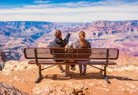 Stock photograph of a family with one child looking at view in Grand Canyon National Park, South Rim, USA on a sunny day.