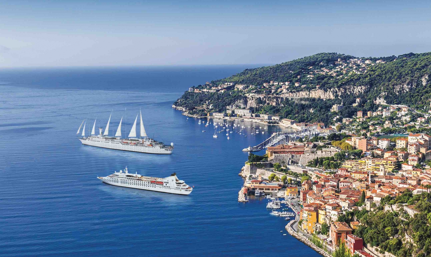 Two cruise ships off a colorful coast