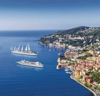 Two cruise ships off a colorful coast