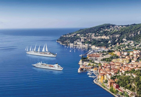 Two cruise ships off a colorful coast