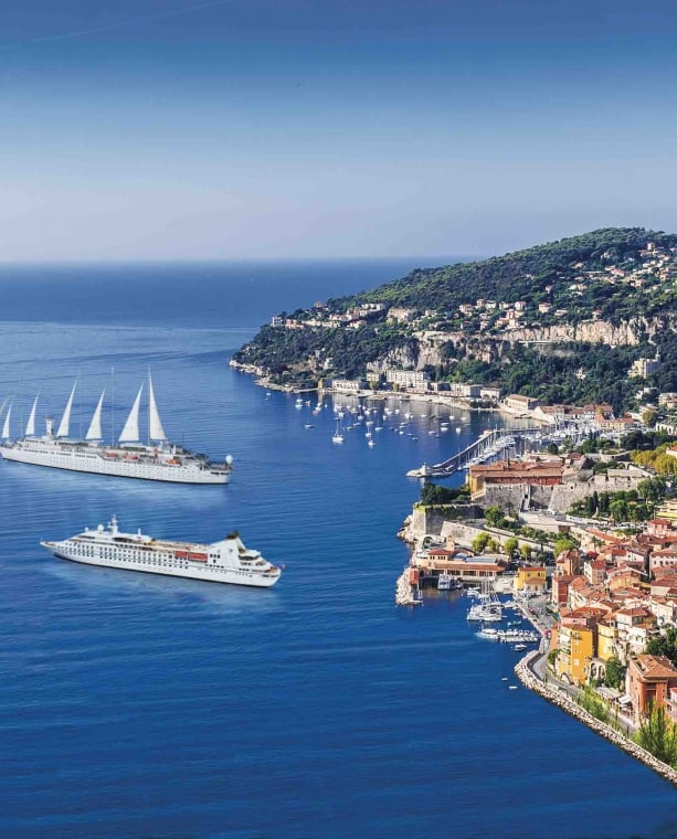 Two cruise ships off a colorful coast