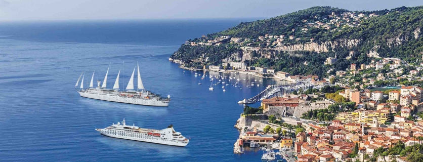 Two cruise ships off a colorful coast