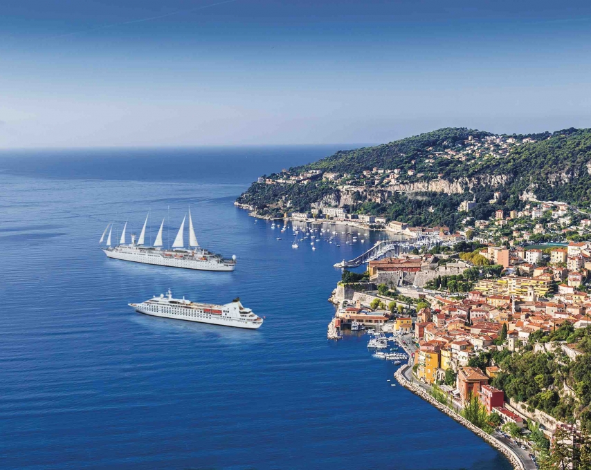 Two cruise ships off a colorful coast