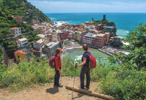 Two hikers overlooking a colorful cityscape