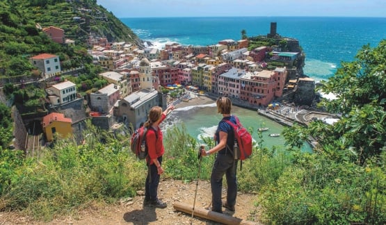 Two hikers overlooking a colorful cityscape