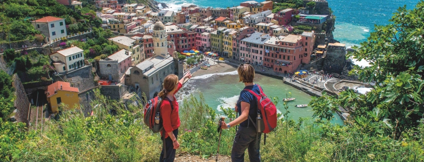 Two hikers overlooking a colorful cityscape