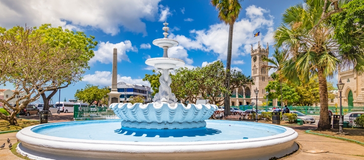 White empty fountain with sculpture in the city center of Bridgetown, Barbados. Bright and colorful image with blue sky and white clouds on a summer day.