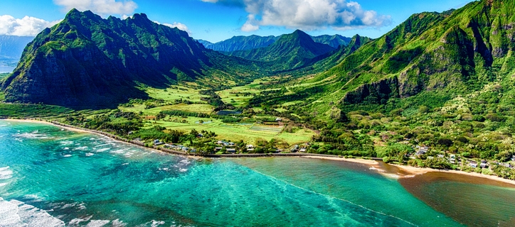 The beautiful and unique landscape of coastal Oahu, Hawaii and the Kualoa Ranch where Jurassic Park was filmed as shot from an altitude of about 1000 feet over the Pacific Ocean.