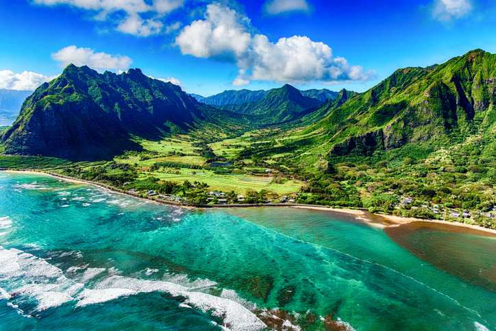 The beautiful and unique landscape of coastal Oahu, Hawaii and the Kualoa Ranch where Jurassic Park was filmed as shot from an altitude of about 1000 feet over the Pacific Ocean.