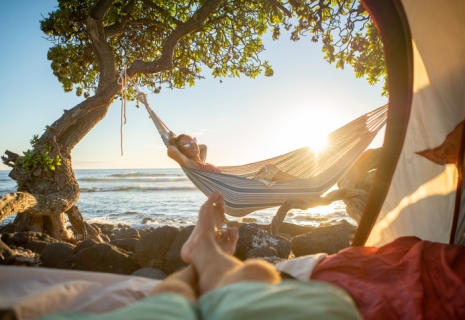 Point of view of man's feet from inside a tent camping on the beach in Hawaii looking at girlfriend in hammock outdoorsst Romantic Locations 4