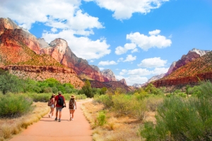 People on hiking trip in the mountains walking on pathway. Zion National Park, Utah, USA