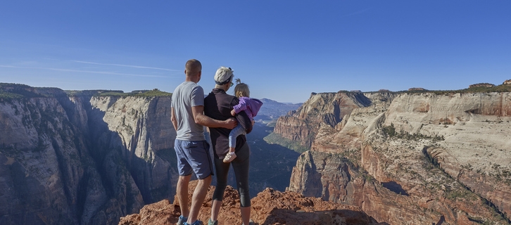 Family at the edge of Zion Canyon in the breathtakingly beautiful scenery of Zion National Park in southern Utah.
