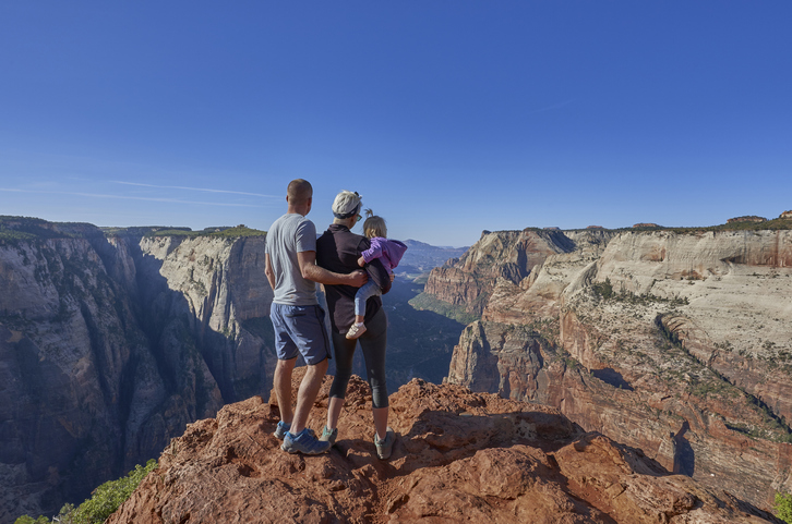 Family at the edge of Zion Canyon in the breathtakingly beautiful scenery of Zion National Park in southern Utah.